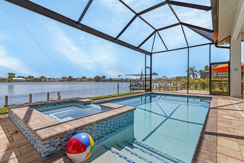 Welcome to your private waterfront oasis! Enjoy mornings in the paver-screened lanai featuring a heated saltwater pool and built-in spa.