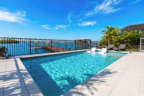 A pristine backyard waterfront pool with a private dock.