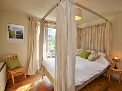Four-poster bed with views out of the window across the countryside