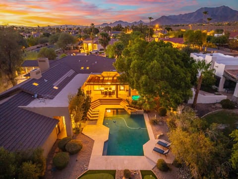 Sunset aerial view with private pool and mountain backdrop.