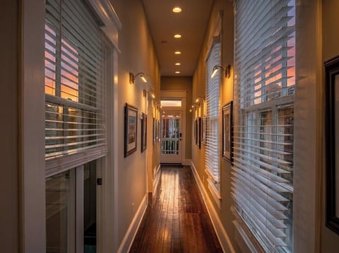 The gallery-style hallway sets the tone, lined with framed horse racing art under warm picture lights.