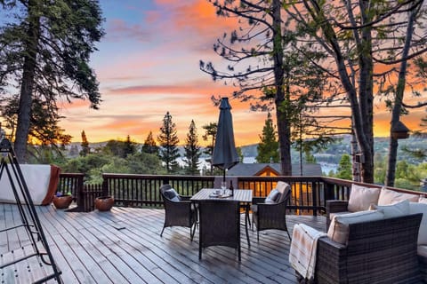 Unwind on the spacious deck as the sun sets over the lake, with cozy seating and peaceful treetop views all around.