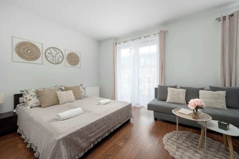 Bright bedroom with a comfortable double bed, sofa, coffee table, and large windows letting in plenty of natural light.