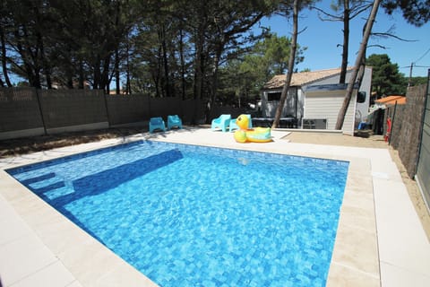 In ground heated swimming pool with fully electric cover, beach end, steps.