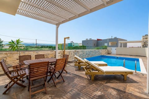Private pool with shaded outdoor dining and comfortable sun loungers.