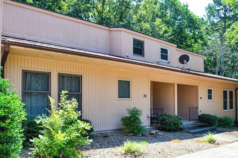 Modern two-story property nestled in a peaceful wooded setting, featuring multiple units and convenient parking access.
