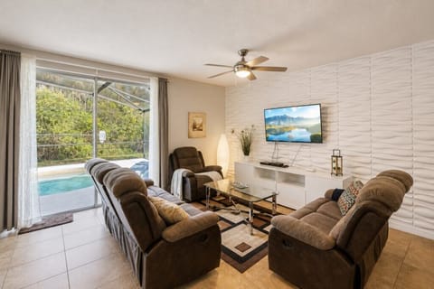 Cozy living room with recliners and pool view, perfect for relaxation and entertainment.