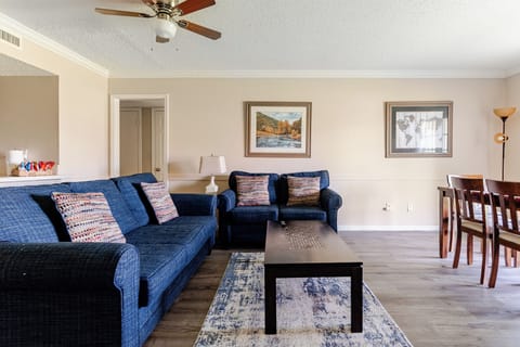 Bright living room with plush blue seating and adjacent dining space