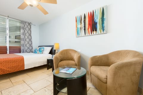 Your bright coastal retreat awaits with a comfy bed, cozy seating nook, and vibrant art to inspire your beach-town getaway. Relax in air-conditioned comfort under gentle ceiling fan breezes.