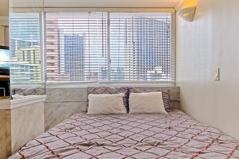 Wake up each morning in this chic bedroom, where large windows frame stunning city views and soft linens invite you to relax.