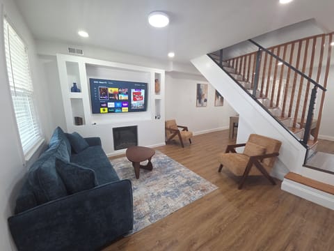 Bright modern lounge with fireplace, large TV, and stylish open layout