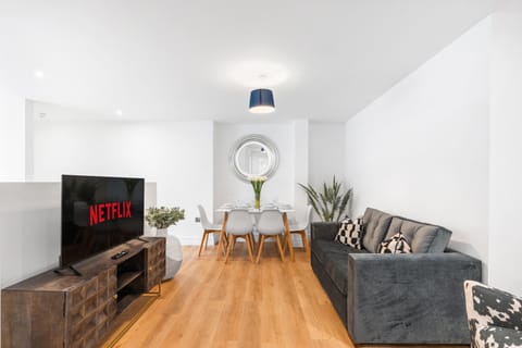 Bright open-plan living room with comfortable seating, Smart TV and a modern coastal-inspired interior.