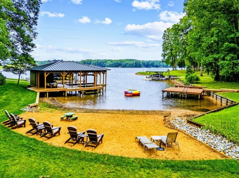Private Beach - The cove from above: beach seating, swim dock, and the water trampoline waiting offshore.