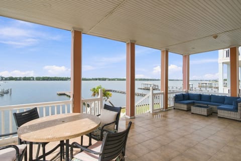 Covered waterfront balcony with dining and seating over Little Lagoon