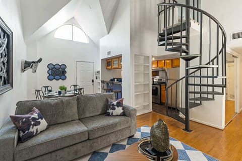 Charming living area with spiral staircase and modern kitchen, perfect for relaxing and entertaining.