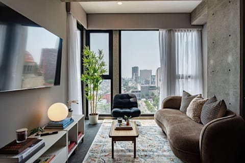 Enjoy the inviting living area with floor-to-ceiling windows and beautiful city views.
