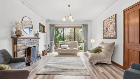 Relax in the welcoming living room featuring comfortable seating, a charming fireplace, and plenty of natural light.