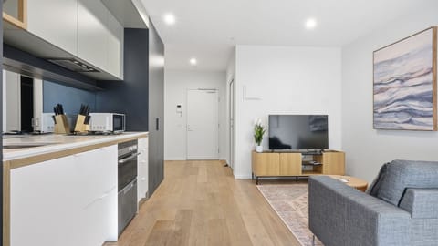 The sleek open-plan layout blends the kitchen, living, and dining areas into one stylish space.