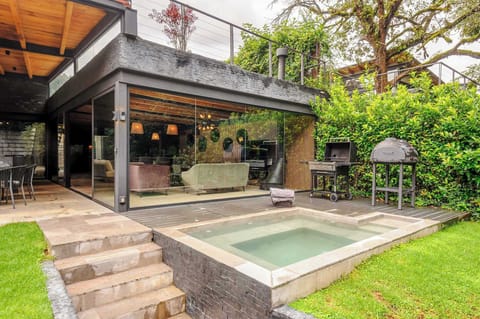 A built-in grill and wood-fired pizza oven sit ready just steps from the hot tub.