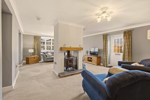 Spacious living room with wood mantel fireplace and comfortable sofa seating