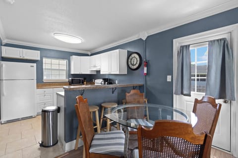 The layout seamlessly connects the dining table to a handy breakfast bar with extra stool seating, perfect for casual mornings.