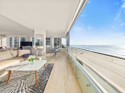 The living room glass opens to the sea, the sand directly below.