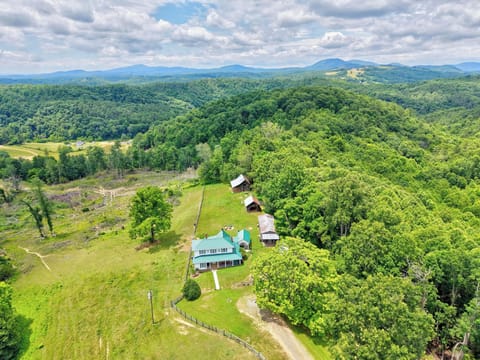 An aerial view of a secluded country estate nestled in vast, rolling forests.