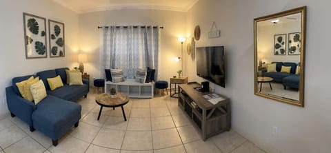 Living Room: Living room with a comfy sofa, smart TV, and ceiling fan — perfect for movie nights or relaxing after a day in the sun.