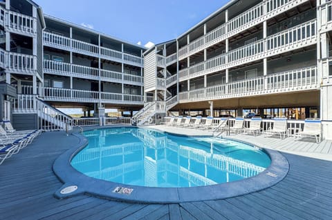 Resort-style outdoor swimming pool surrounded by private balconies