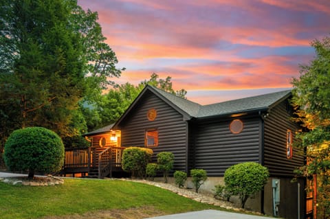 Cozy log cabin with sunset views, lush landscaping, and a welcoming porch