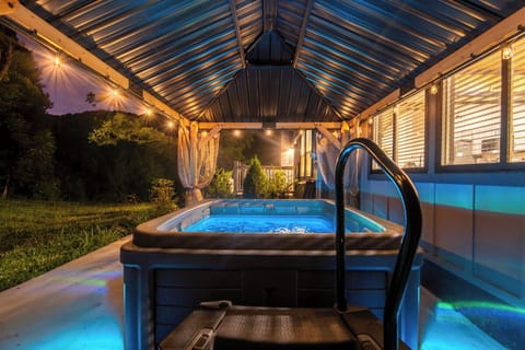 Your private hot tub awaits, glowing softly as evening settles in. Slip into the warm, bubbling water and unwind beneath twinkling lights, with the peaceful garden just beyond.