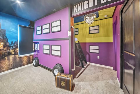 Welcome to a vibrant bedroom featuring playful purple and yellow accents. The truck-shaped bed sparks creativity, while soft carpeting promises cozy nights. A charming chandelier adds a magical touch to this delightful retreat.