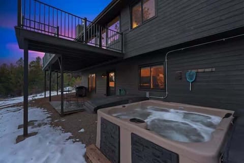 Private hot tub tucked below the deck with forest views