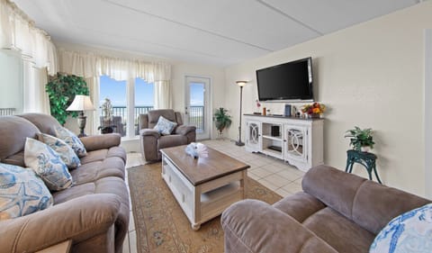 Living room in a Condo on South Padre Island featuring a brown sofa, TV, and coffee table