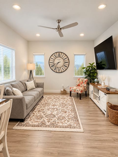 Bright, cozy living room with big TV, stylish décor, and plenty of natural light