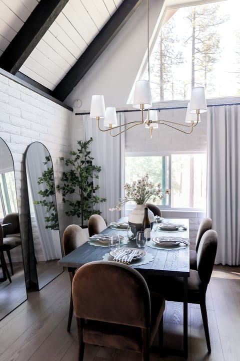 Light-filled dining space with vaulted ceilings and peaceful woodland views