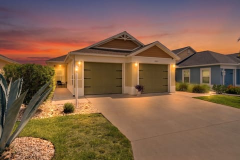 This inviting vacation rental is nestled in a peaceful neighborhood with modern comfort and charm, featuring a two-car garage and beautifully landscaped yard welcoming your arrival at sunset.