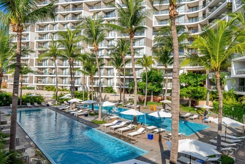 Refresh your senses in this massive, sparkling blue swimming pool area, lined with plenty of comfortable lounge chairs, shade umbrellas, and towering tropical palm trees.