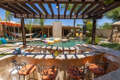 A gorgeous 4 bedroom, 4.5 bathroom home in Palm Springs, CA with 2 casitas, a lazy river, swim up bar, pickleball, basketball, putting green, games, and more!