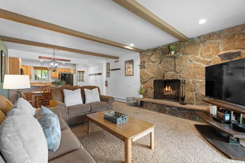 Gather by the crackling fireplace and sink into plush sofas in your inviting living room. Exposed beams, natural stone, and warm wood tones create a cozy mountain retreat for memorable evenings.