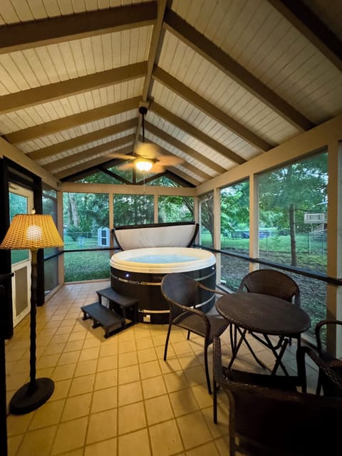Screened sunroom with private hot tub and cozy lounge seating