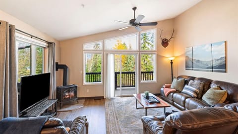Cozy living room with gas fireplace, HDTV with streaming capabilities, vaulted ceilings, walk out balcony with alpine views