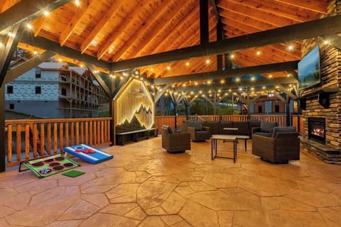 Covered pavilion with fireplace, TV, lounge seating, and fun yard games