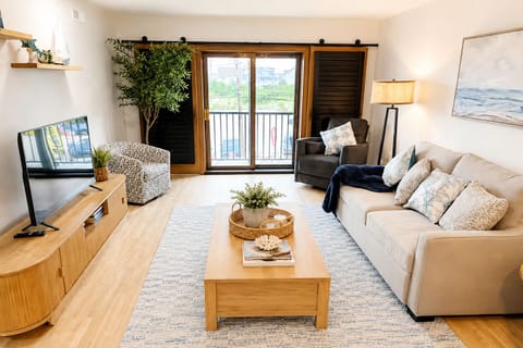 Bright, cozy living room with balcony access and stylish coastal decor