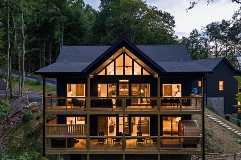 This is where mountain evenings begin. Two levels of outdoor living, warm cabin interiors, a private hot tub, and barrel sauna tucked into the woods.