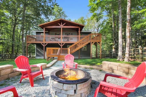 Escape to a wooded mountain cabin retreat, where a covered deck invites you to soak in the fresh forest air and a crackling fire pit sets the scene for unforgettable evenings under the stars.