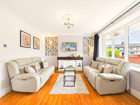 This bright living room beautifully balances modern comfort with fun tropical accent wallpaper, creating a warm, energetic atmosphere for your stay.