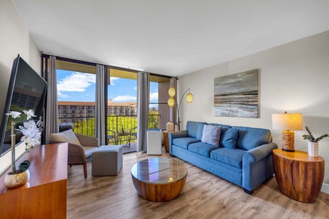 Bright and comfortable living room with cozy seating, smart TV, and large sliding doors that open to your private lanai.
