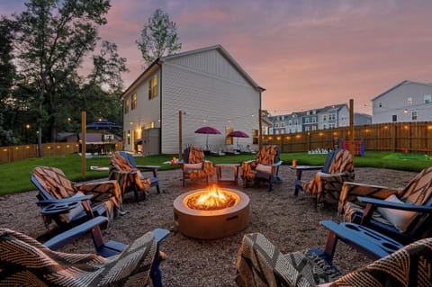 Cozy backyard fire pit with Adirondack seating, lawn games, and sunset vibes