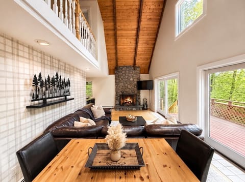 Your cozy woodland escape with vaulted wood ceilings, plush seating, and warm fireside ambiance.